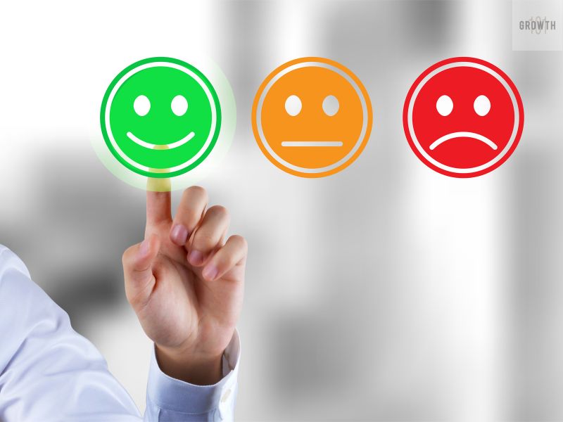 A person selecting a green smiley face on a feedback scale, symbolizing customer satisfaction and the importance of delighting customers to grow a business.