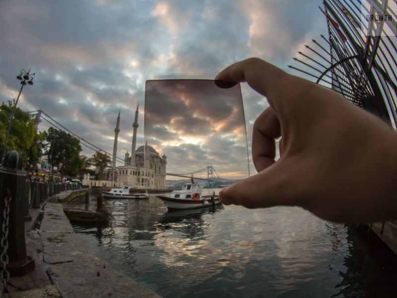 A hand holding a filter over a scenic view, symbolizing a focused approach to evaluating freelancers in a small business setting.