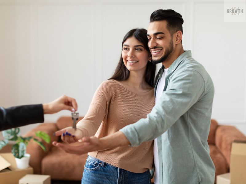 Happy couple receiving keys to their new home, representing a buyer persona example of young homeowners reaching their goals.