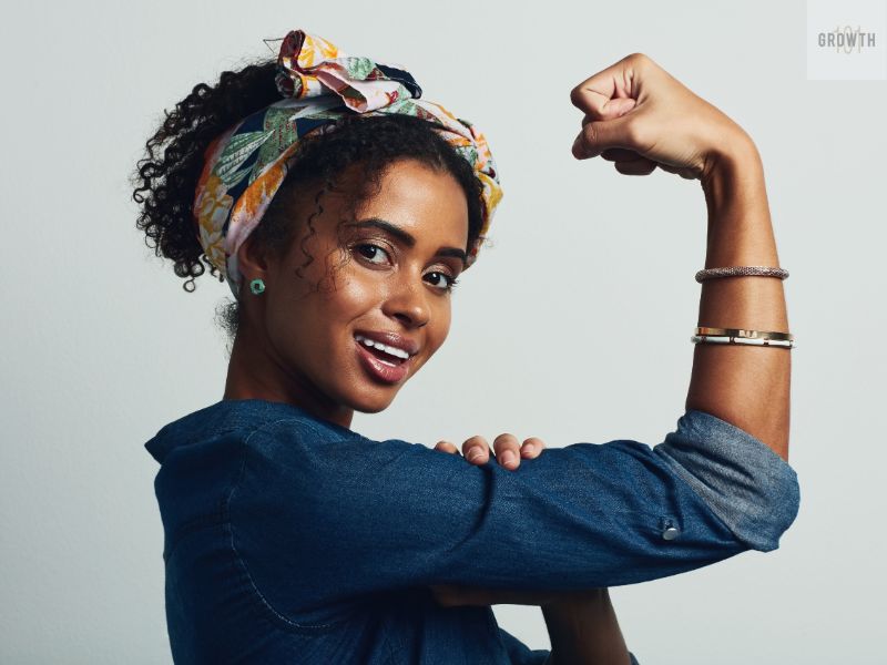 Confident woman flexing her arm, symbolizing strength and empowerment in finding your niche.