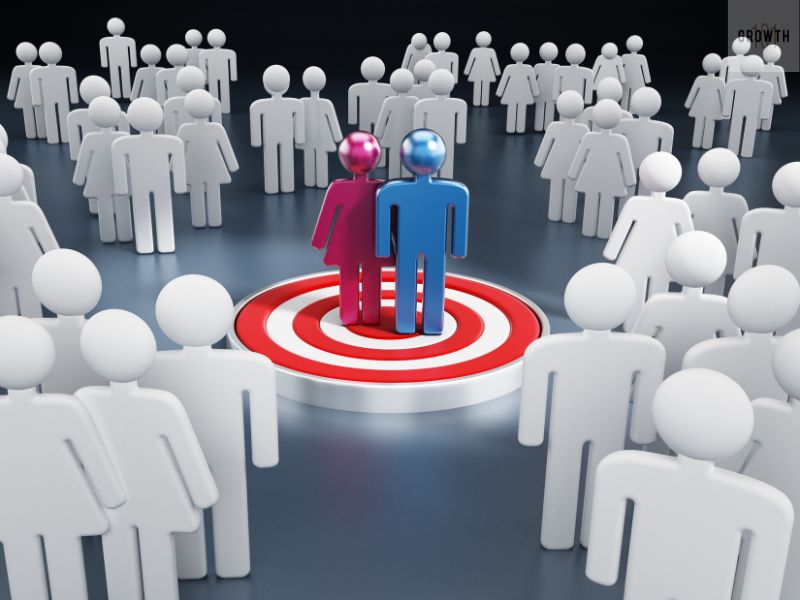 Two figures standing on a target surrounded by a crowd, representing the concept of finding and focusing on a target audience.