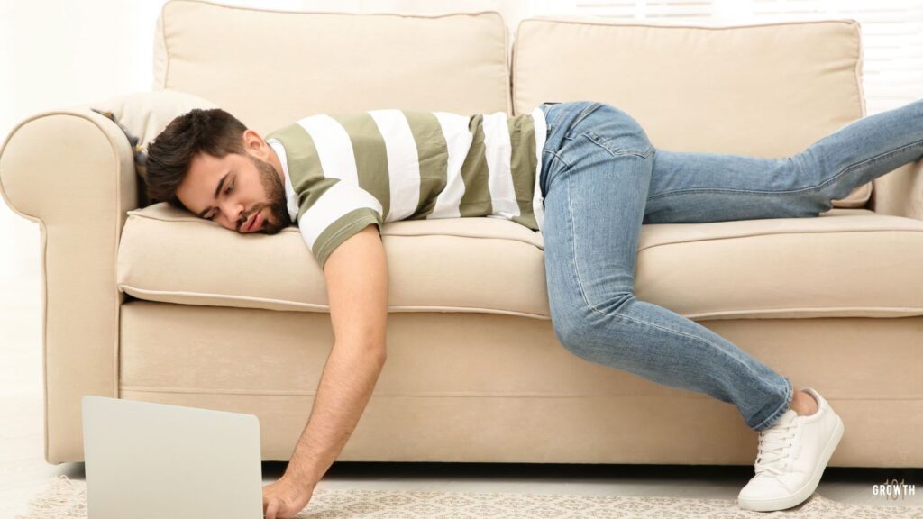 Image of a man on couch looking at his laptop which is on the floor which symbolises preparation