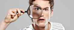 Man holding a magnifying glass, searching for focus, symbolizing how to find my niche in business.