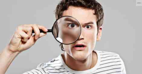 Man holding a magnifying glass, searching for focus, symbolizing how to find my niche in business.