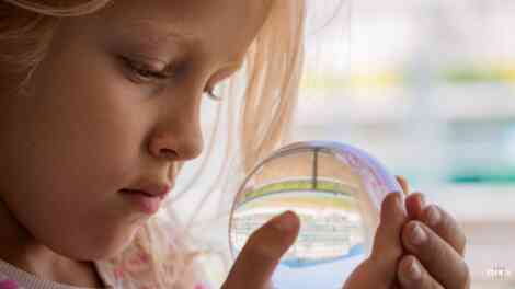 Image of a young child viewing a model of an enclosed world.