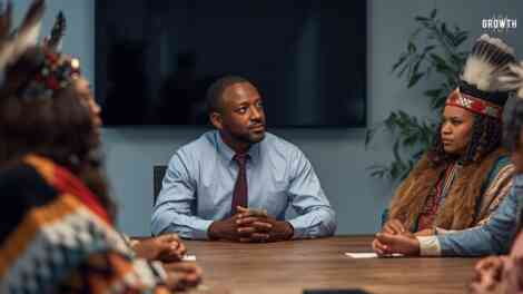 Image of a technology leader having a conversation with his favourite employees but they are all dressed in native american wear.