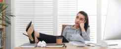 woman with feet up on office desk wasting time
