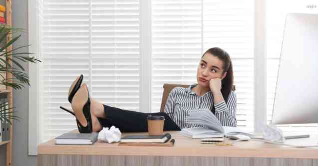 woman with feet up on office desk wasting time